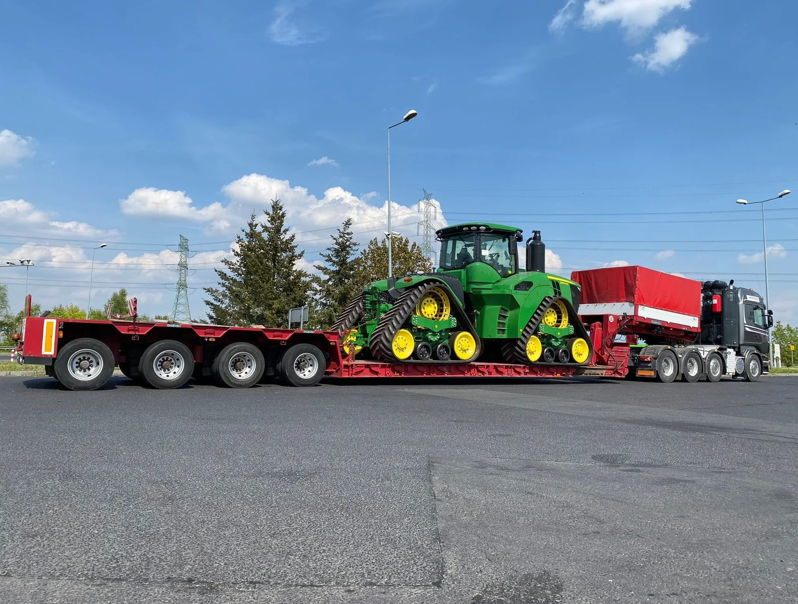 Ciągnik gąsienicowy John Deere 9RX na 4-osiowej naczepie Tiefbett Gonera Transport