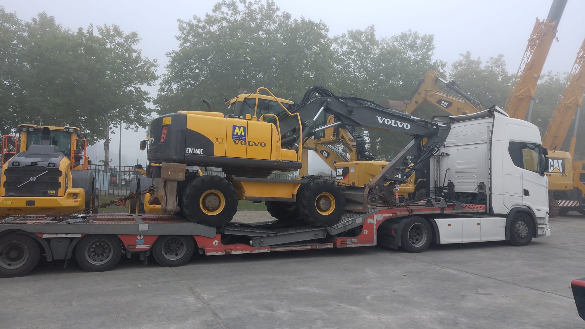 Koparka kołowa na zestawie transportowym Gonera Transport